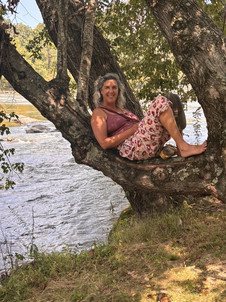 Dana Smirin relaxing in a tree over a river
